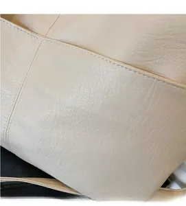 Close-up of beige lychee grain leather tote bag showing fine texture and neat stitching