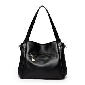 Large black textured leather bucket bag with gold heart charm and top handle strap