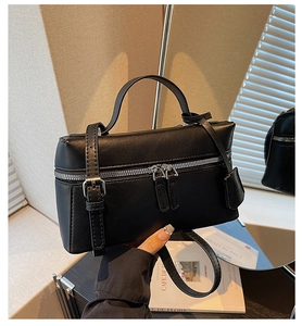 Détail du sac à main rectangulaire en cuir noir avec doubles fermetures éclair argentées