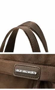 Detail van versterkte handvatten en metalen logo op de donkerbruine nylon tote bag