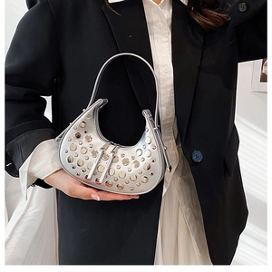 Detailed shot of silver Hobo bag with metallic studs and glossy finish on handle
