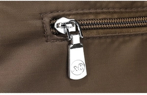 Detail van de metalen rits met AR-logo op een stijlvolle koffiebruine nylon draagtas