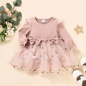 Detail of baby girl pink knit dress with floral embroidery mesh skirt and bows