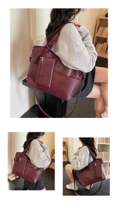 Detail of burgundy leather tote bag showing grainy texture and small zip pouch charm