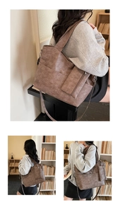 Detailed view of brown matte leather tote bag with wide shoulder strap for daily commute