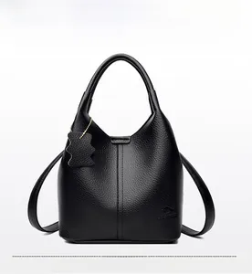 Détail d'un sac seau en cuir grainé noir avec poignée supérieure et bandoulière