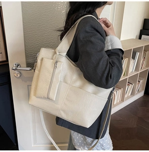 Detail of beige large capacity PU leather tote bag with matching square coin purse accessory