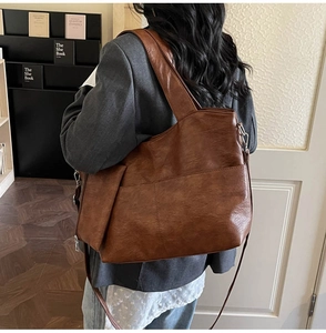 Close-up of vintage brown PU leather tote bag with silver hardware and dual straps