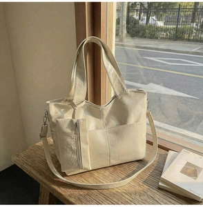 Detail of cream PU leather tote bag featuring subtle texture and a matching small pouch