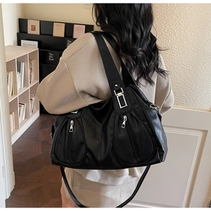 Detail of black PU leather tote bag with dual front zippers and silver metal hardware