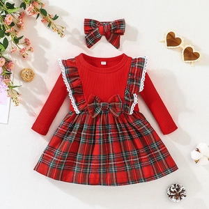 Detail of red plaid baby dress featuring white lace ruffles and matching bow headband