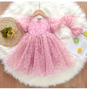 Vue à plat d'une robe rose fleurie pour fille avec manches bouffantes et bandeau assorti