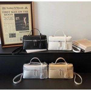 Detail shot of mini box bags in black, white, silver, and gold with top handles