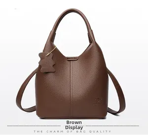 Détail de la texture cuir marron grainé et du logo de la marque kangourou sur le sac