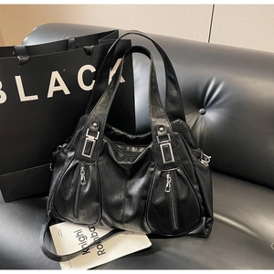 Detail of black tote bag with textured faux leather and silver zipper hardware