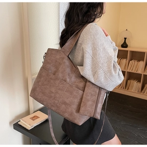 Detailed side view of dark brown PU leather tote bag with matching zipper pouch