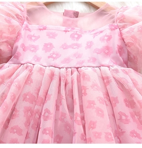 Détail d'une robe de princesse rose pour fille avec manches bouffantes et tulle multicouche