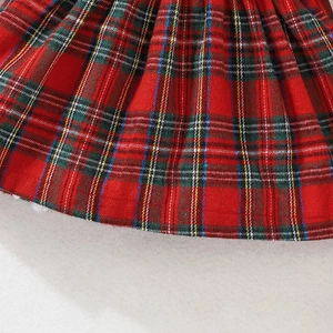 Close-up detail of classic red and green tartan plaid fabric with soft pleated texture