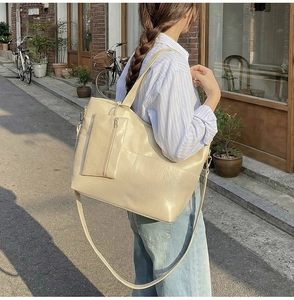 Detail of off-white large tote bag with matching zipper pouch and wide shoulder strap