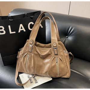 Brown leather tote bag featuring dual front zipper pockets and adjustable shoulder strap