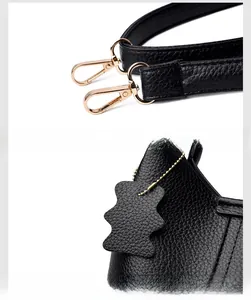 Détail du sac en cuir noir avec ferrures dorées et breloque en forme d'ours