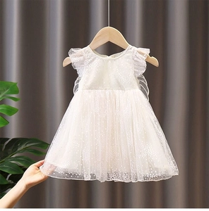 Close-up of white mesh tulle girl dress featuring layered lace ruffles and wing detail