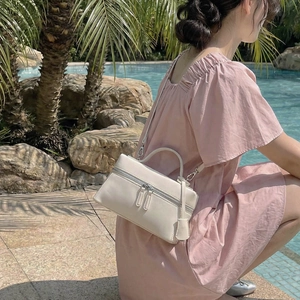 Détail du sac bandoulière carré crème avec double fermeture éclair et anse fine