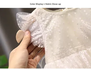 Detail of cream tulle fabric and delicate floral lace on the girls' butterfly sleeves