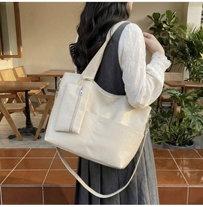 Close-up of a large beige PU leather tote bag with a small matching zip pouch
