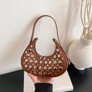 Vintage brown hobo bag with silver rivets and double zipper in a lifestyle setting