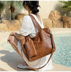 Brown vintage PU leather tote bag with small pouch and shoulder strap by the pool
