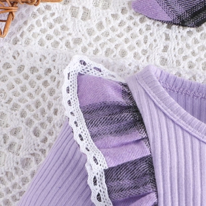 Detail of baby dress with purple ribbed fabric, plaid ruffles and white lace trim