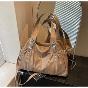 Close-up of soft khaki PU leather tote bag with vertical zippers and silver metal hardware