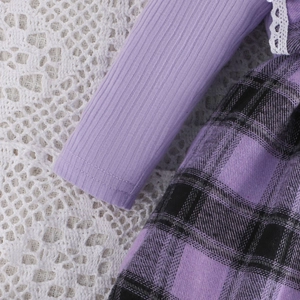 Detail of purple plaid dress featuring ribbed knit cuffs and delicate white lace edges