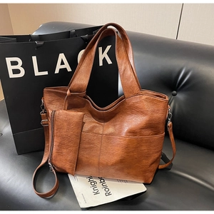 Detail of vintage brown PU leather tote bag with small detachable zipper pouch on side