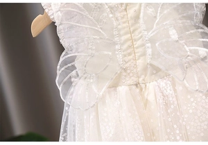 Detail of white lace butterfly embroidery and layered mesh tulle on girl's princess dress