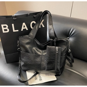 Detail of black PU leather tote bag texture with matching small detachable coin purse