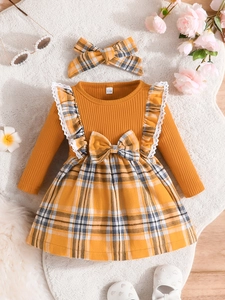 Detail of infant long sleeve mustard yellow knit dress with plaid bow and matching headband