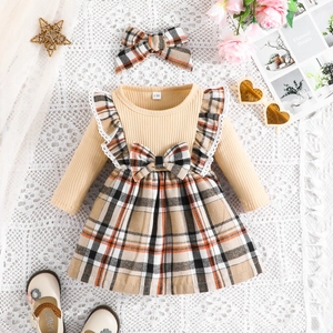Detail of baby girl plaid dress with matching bow headband and ribbed knit top