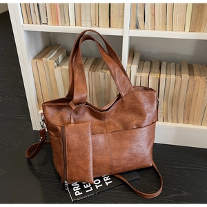 Detail of dark brown tote bag with cross stitching and detachable small pouch