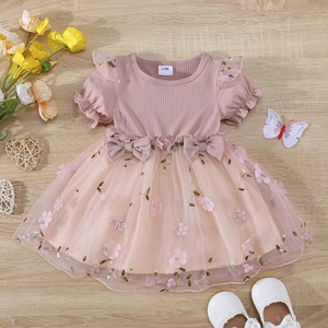 Close-up of pink baby girl dress with mesh skirt featuring floral embroidery and bows
