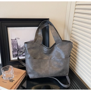 Detail of grey vintage textured PU leather tote bag with functional front pocket and strap