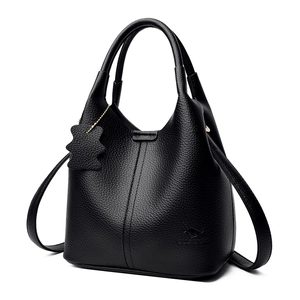 Sac à main élégant en cuir noir grainé avec doubles poignées et breloque ours