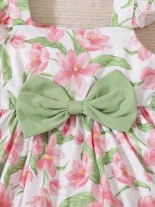 Close-up of floral print baby top with pink cherry blossoms and light green fabric bow