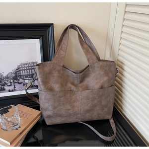 Detail of vintage brown PU leather tote bag with cross stitching and large front pockets