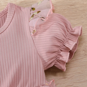 Detail of baby girl pink ribbed dress with mesh ruffles and gold leaf embroidery
