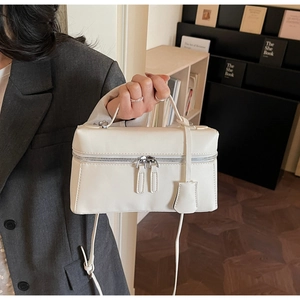 Vue détaillée d'un sac vanity blanc rectangulaire en cuir avec fermetures éclair argent