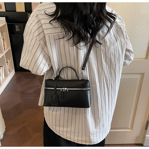 Vue détaillée du mini sac Boston en cuir noir avec fermeture éclair argentée
