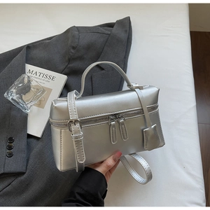Détail d'un sac à main carré argenté avec fermeture à glissière double circonférentielle