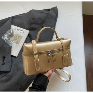Détail du sac carré métallisé or champagne avec poignée et double fermeture éclair